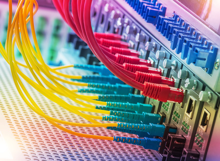 Fiber Optic cables connected to an optic ports and Network cables connected to the portsのeditorial素材