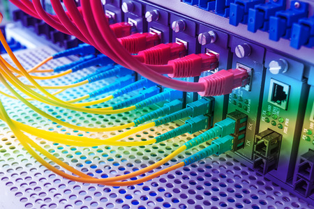 Fiber Optic cables connected to an optic ports and Network cables connected to the portsのeditorial素材