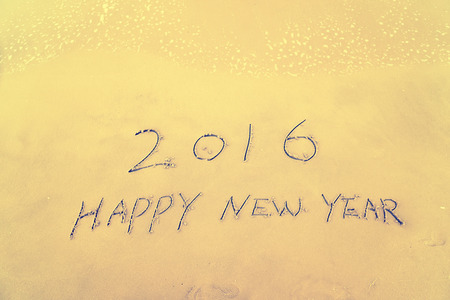 Year 2016 hand written on the white sand in front of the seaの写真素材