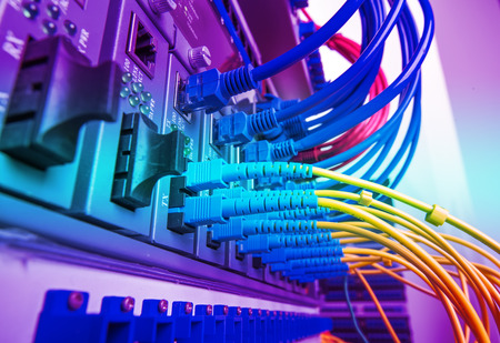 Fiber Optic cables connected to an optic ports and Network cables connected to ports