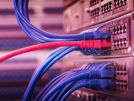 network cables and hub closeup with fiber optical backgroundの写真素材