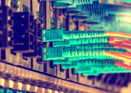 Fiber Optic cables connected to an optic ports and Network cables connected to ethernet ports