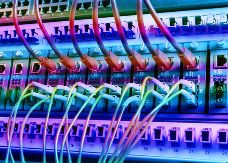 Fiber Optic cables connected to an optic ports and Network cables connected to portsのeditorial素材