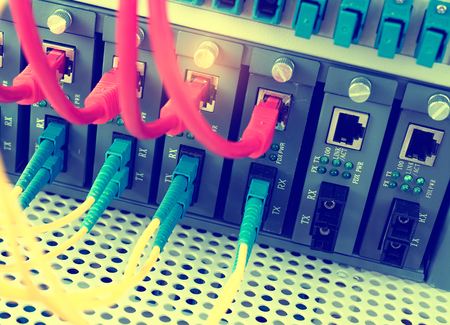 Fiber Optic cables connected to an optic ports and Network cables connected to portsのeditorial素材