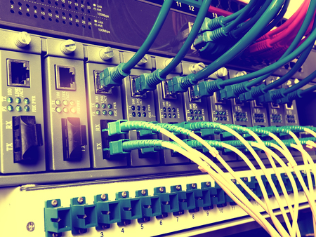 Fiber Optic cables connected to an optic ports and Network cables connected to portsのeditorial素材