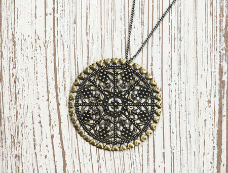 Vintage pendant on white wooden backgroundの写真素材