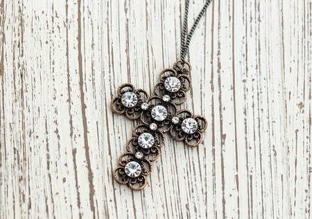 cross pendant on wood backgroundの写真素材