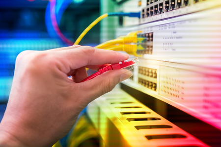 hand with network cables connected to servers