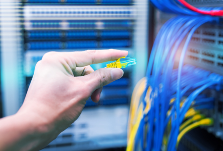 administrator holding network cables connected to servers