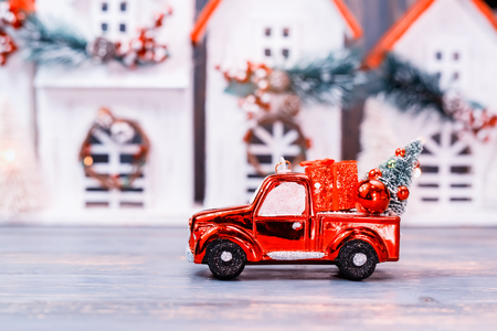 christmas ornaments and car toy with tree presents on wooden house background. merry christmas concept.の写真素材