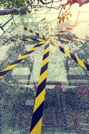 Yellow tape across broken glass window
