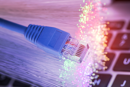 network cables and fiber optic closeup with keyboard backgroundの写真素材