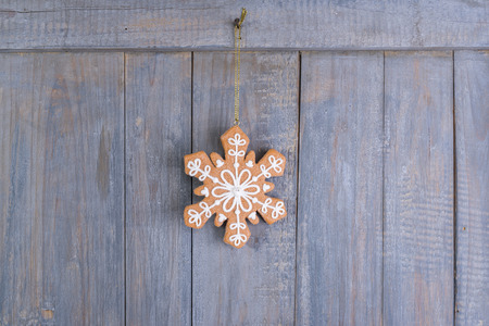 Gingerbread snowflakes cookies for Christmas hanging on wooden background.の写真素材