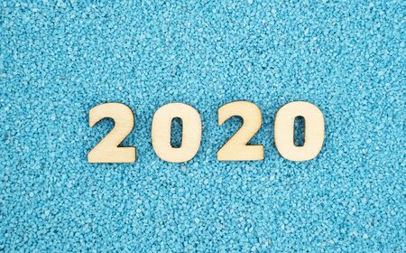 Happy New Year 2020 concept, Wood block 2020 on blue sand background