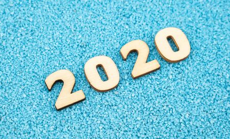 Happy New Year 2020 concept, Wood block 2020 on blue sand background