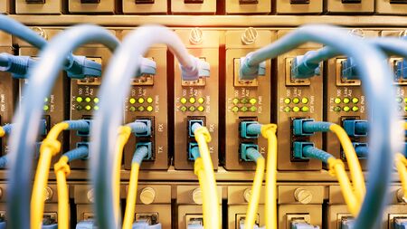 Fiber Optic cables connected to an optic ports and Network cables connected to ethernet ports