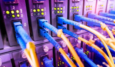 Fiber Optic cables connected to an optic ports and Network cables connected to ethernet ports