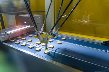automate robot with vacuum suckers with conveyor in Production of biscuits in a manufacture factory...