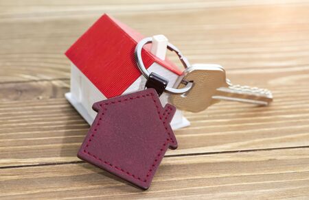 key chain with house symbol and keys on wooden background,Real estate conceptの写真素材