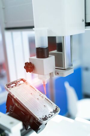 Robot holding glue syringe Injection in mobile phone factory