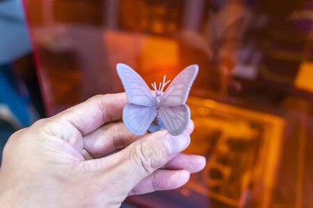 hand with object in shape of butterfly toy printed on 3d printer