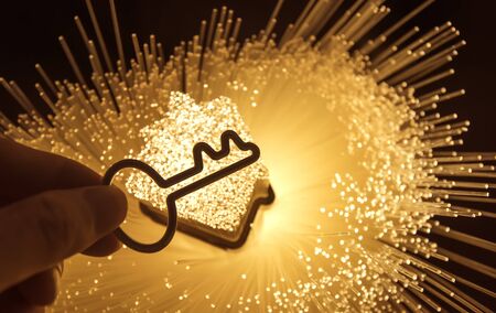 hand holding key with house shape background,smart home technology with fiber optic connectionの写真素材