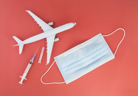 Airplane model, respiratory protection medical masks and disposable syringe.Concept of coronavirus, COVID-19 pandemic, global quarantinの写真素材