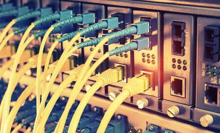 Fiber Optic cables connected to an optic ports and Network cables connected to ethernet ports