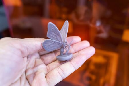 hand with object in shape of butterfly toy printed on 3d printer