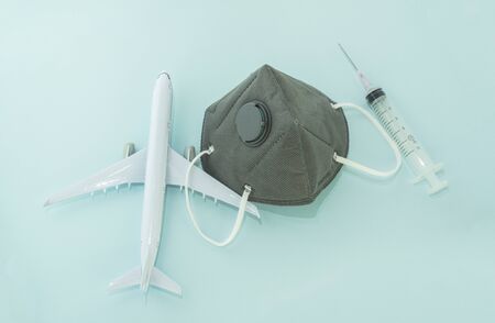 Airplane model, respiratory protection medical masks and disposable syringe.Concept of coronavirus, COVID-19 pandemic, global quarantineの写真素材