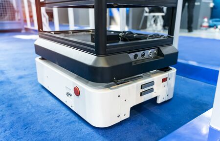 warehouse robot car carries cardboard box assembly in factoryの写真素材