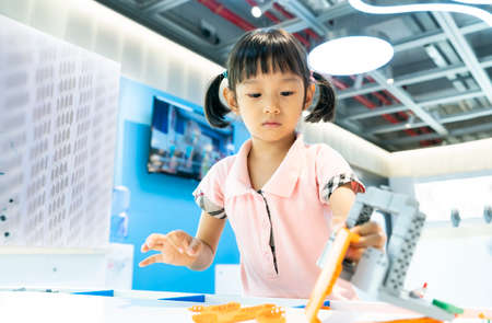asian girl child having fun playing with colorful plastic blocks indoor at play schoolの写真素材