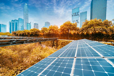 Ecological energy renewable solar panel plant with urban landscape landmarksの写真素材