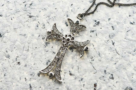 cross pendant on paper backgroundの写真素材