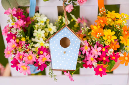 birdhouse hang on spring tree flowers with fenceの写真素材