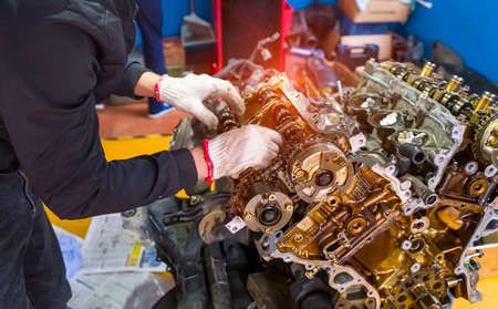 Hands with auto mechanic and engine parts close-up. Car service.
