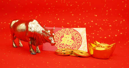 Tradition Chinese 2021 is year of the ox, Chinese characters on rightside gold ingot and coin translation:good bless for money.characters on middle mean: good bless for new yearの写真素材