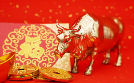2021 is year of the ox,characters on leftside chinese wording mean:Chinese calendar for the year.Chinese characters on gold ingot translation: good bless for money.の写真素材
