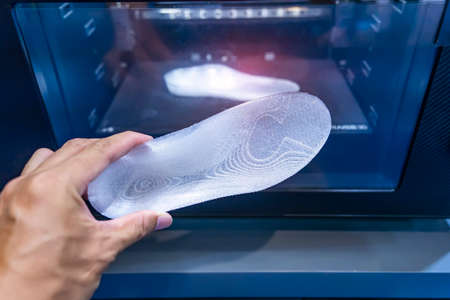 hand with 3d printed shoe figure close-up