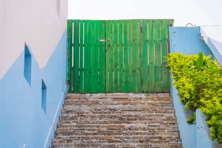 grey stairs and blue historical buildings with green wooden doors