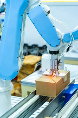 Articulated robotic arm at packaging line in industrial manufacture factory, Smart factory industry 4.0 concept.の写真素材