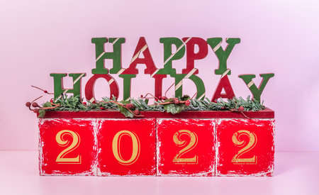 happy holiday and 2022 year concept with red blocks and text board on wooden backgroundの写真素材