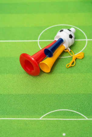 Football soccer triple fan trumpet with toy football on green grassの写真素材