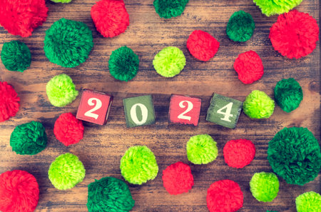 Red and green pompoms with wooden blocks 2024 on woodの写真素材