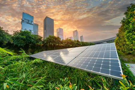 Ecological energy renewable solar panel plant with urban landscape landmarks in sunsetの写真素材