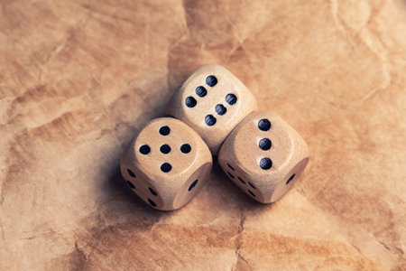 three wooden gambling dice with number six. Gambling dice old paper background
