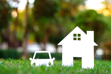 Paper house and car on Greenfield with copy spaceの写真素材