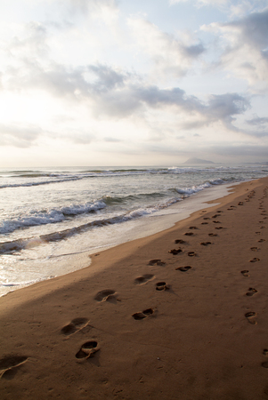 Footprints on the sand on sunriseの写真素材