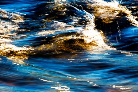 The surface of flowing creek water in sunlight by  long exposure