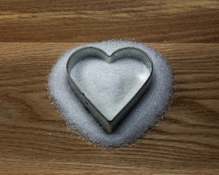 Heart shape cookie mold on the wood and sugarの写真素材